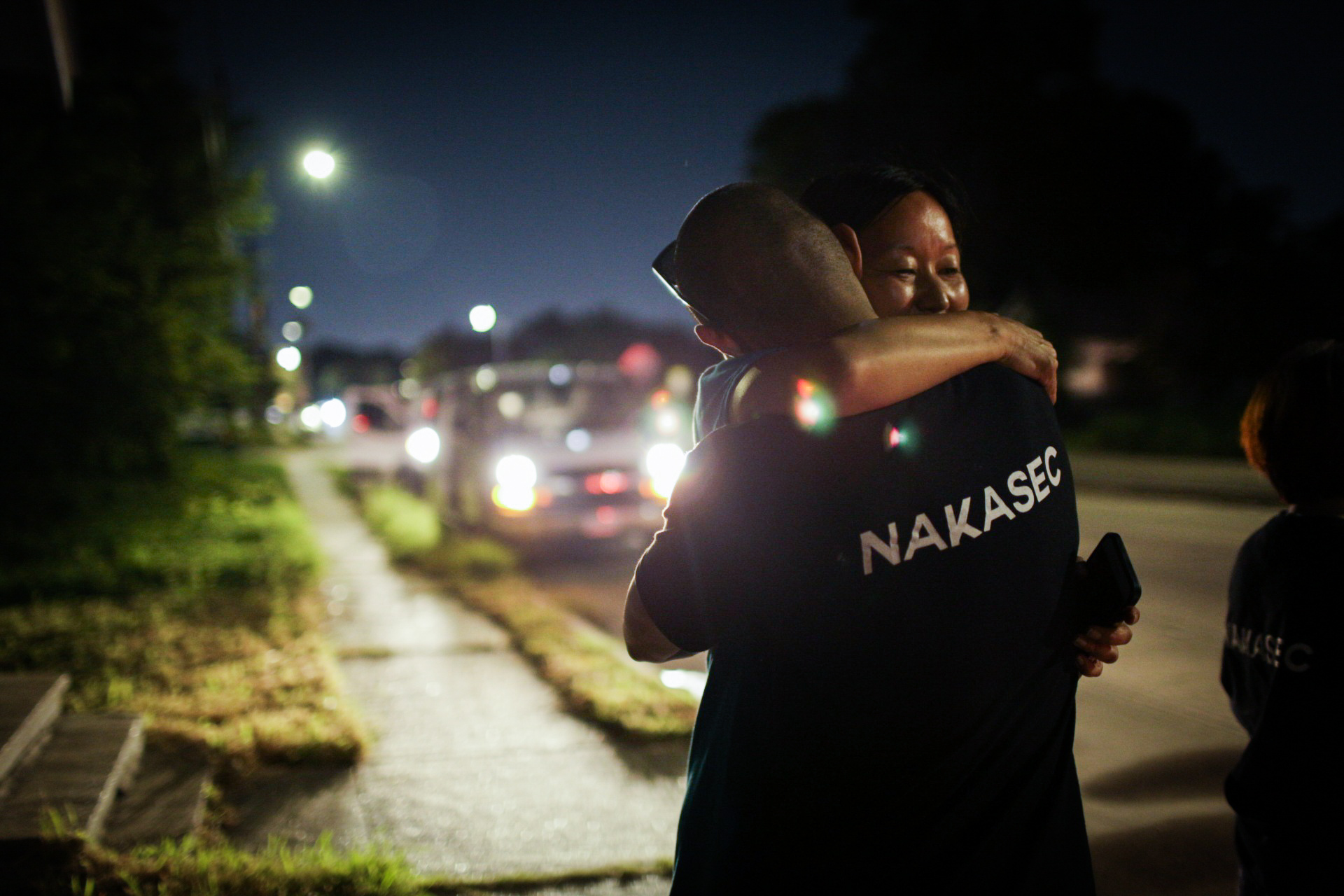 Photograph of two people embracing on a sidewalk
